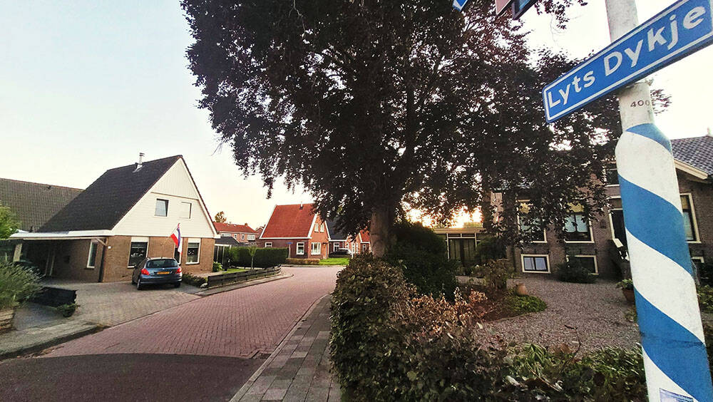 Grou - Een zware trekker van loonbedrijf Krips in Tersoal passeert fietsers op de relatef smalle weg door het aquaduct bij Grou. Een klinkerstrook geeft nog wat extra ruimte, maar de trekkerchauffeur moet door de berm om de naast elkaar fietsende wielrijders te passeren. Met de stijgende temperaturen trekt het voorjaarswerk op de landerijen ook weer aan. Niet alleen trekkers maar ook andere zware landbouwmachines komen dan ook weer de weg op.