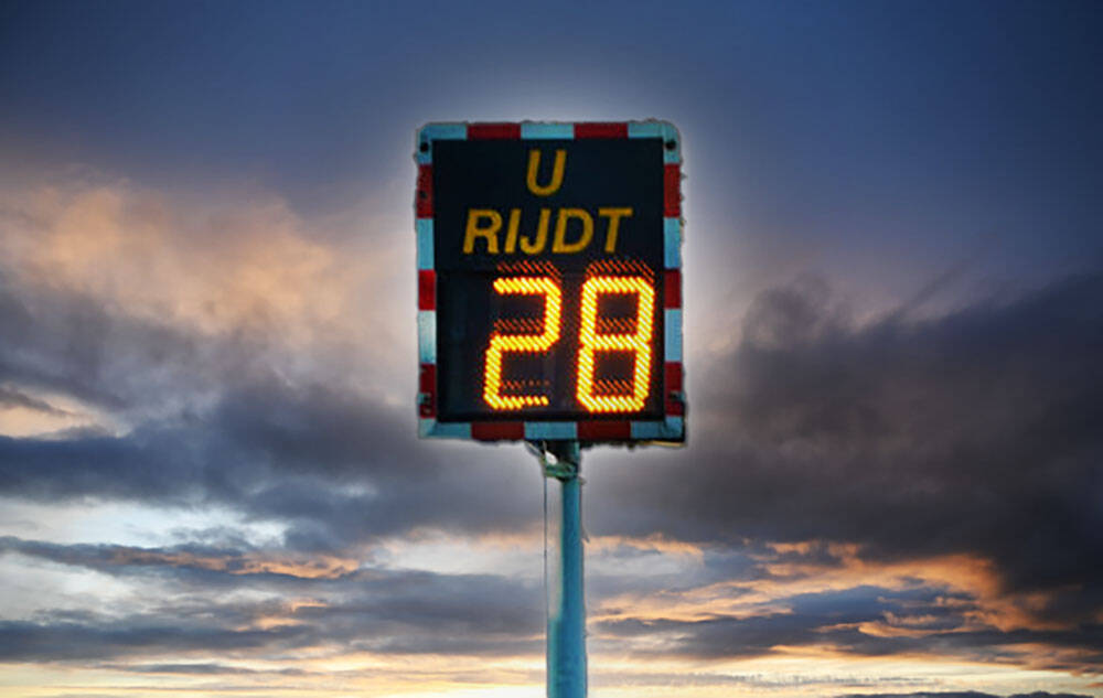 Verkeersborden voor een afzetting met verkeersregelaars: werk in uitvoering, weghelftafzetting en maximmaal dertig kilometer per uur.